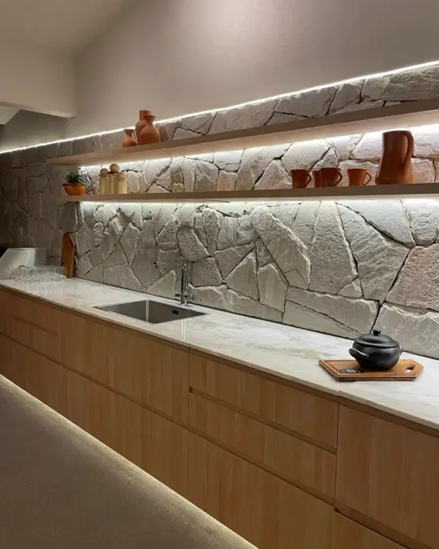 Cozinha com parede de Pedra Atacama iluminada por LED sob as prateleiras